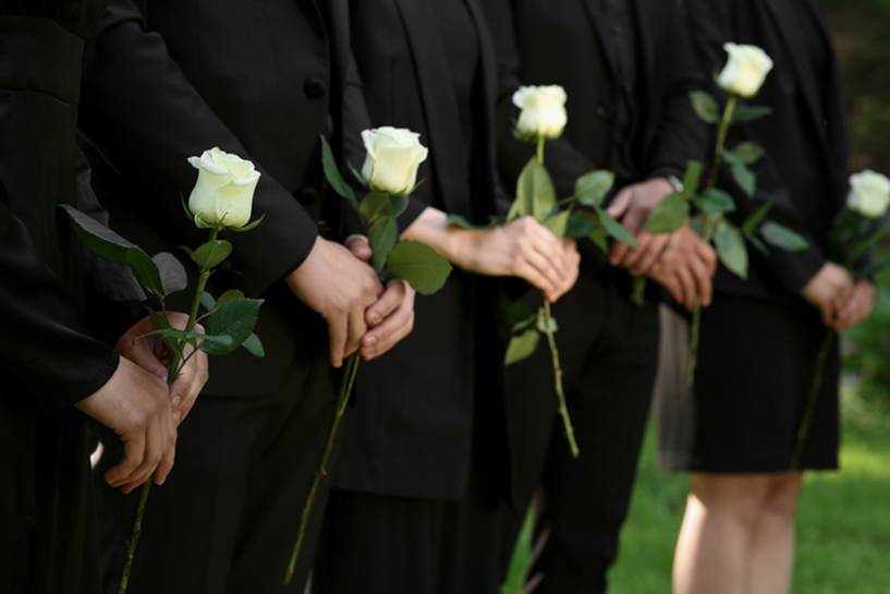 A Funeral attendees holding a white flower